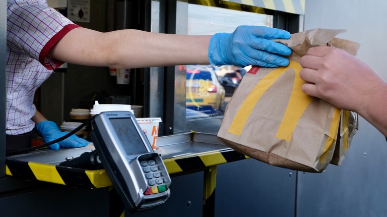 McDonald's worker handing driver bag