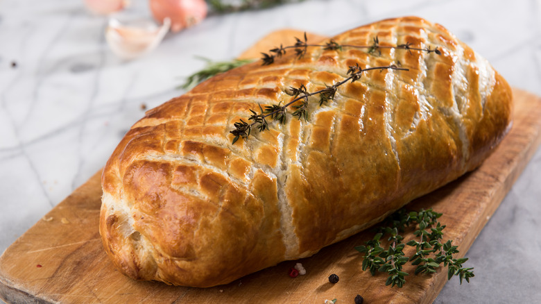 unsliced beef wellington topped with herbs