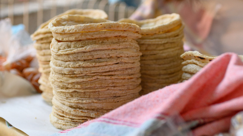 Piles of freshly-made corn tortillas for sale at Mexican supermarket