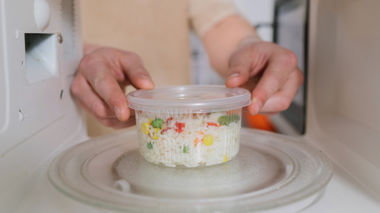 Person putting rice in microwave
