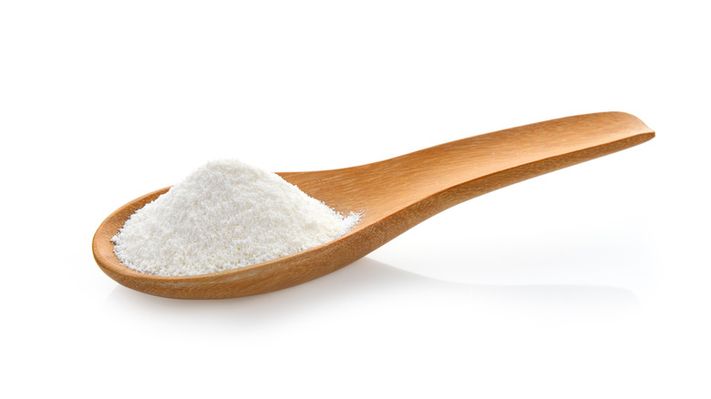 Spoon of white coffee creamer with white background