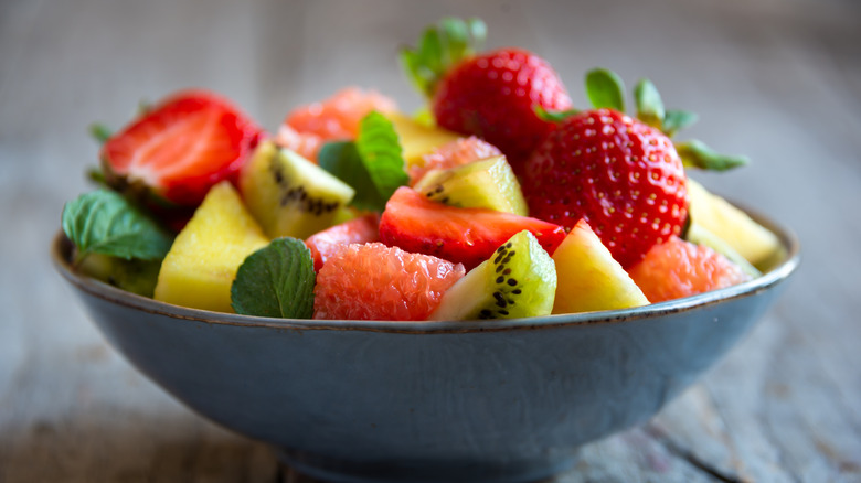 A bowl of summer fruit and mint leaves