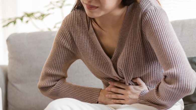 Woman with stomach problem holding her stomach