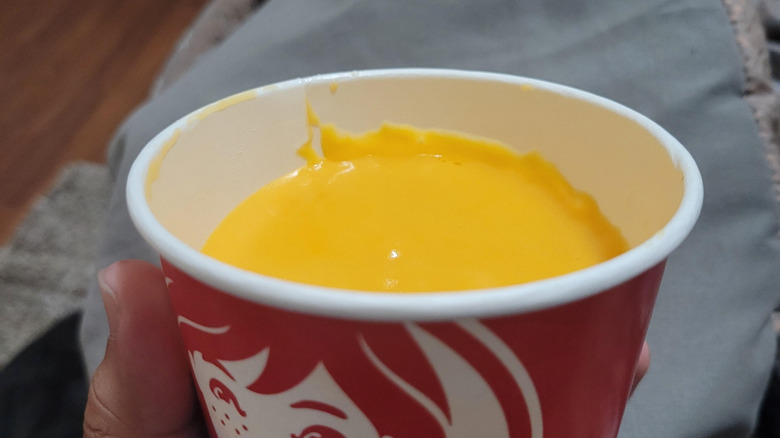 Closeup of cheese sauce in a red Wendy's cup.