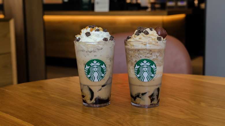 Pair of Starbucks iced coffees with whipped cream and toppings