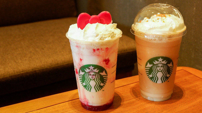 Two Starbucks frappuccinos in plastic takeout cups, with colorful toppings