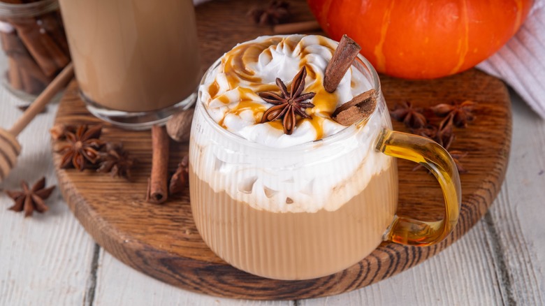 Pumpkin spice latte in a glass mug with cinnamon sticks