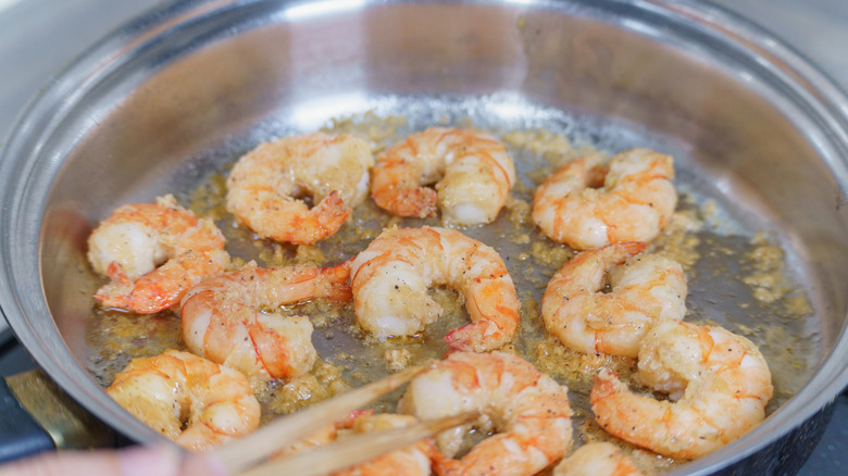 Close up of shrimp cooking in a metal pan