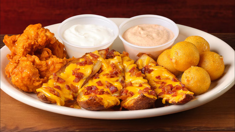 A plate of Texas Roadhouse appetizers include wings, tater skins, and rattlesnake bites