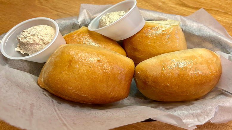 Close up of Texas Roadhouse rolls and honey cinnamon butter in a basket
