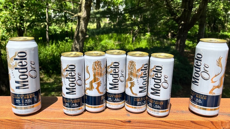 Seven Modelo Oro cans outside