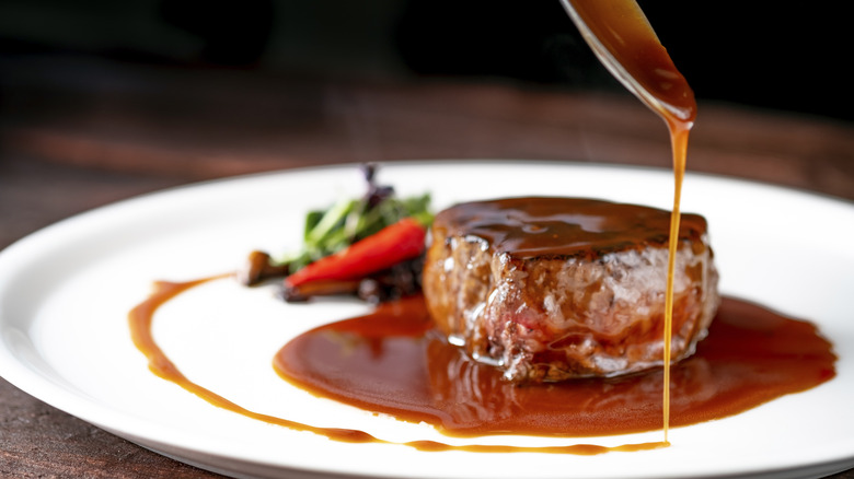 Drizzling filet with demiglace sauce