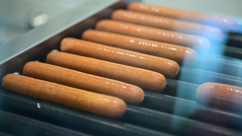 hot dogs cooking on rollers