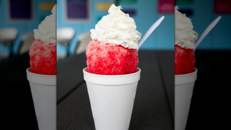 white cup with red snow cone and whipped cream