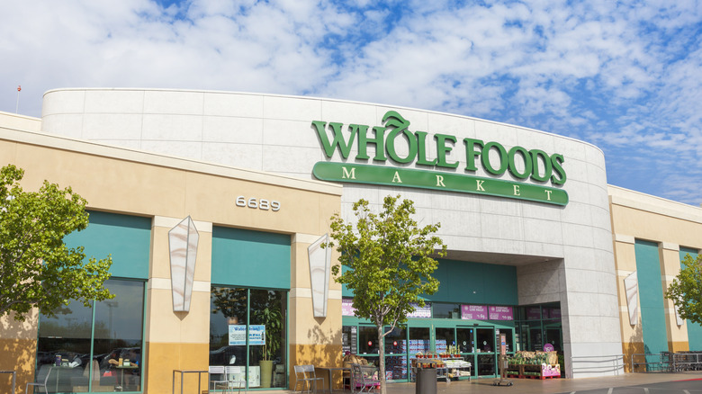 A storefront of Whole Foods Market on a sunny day with trees out front