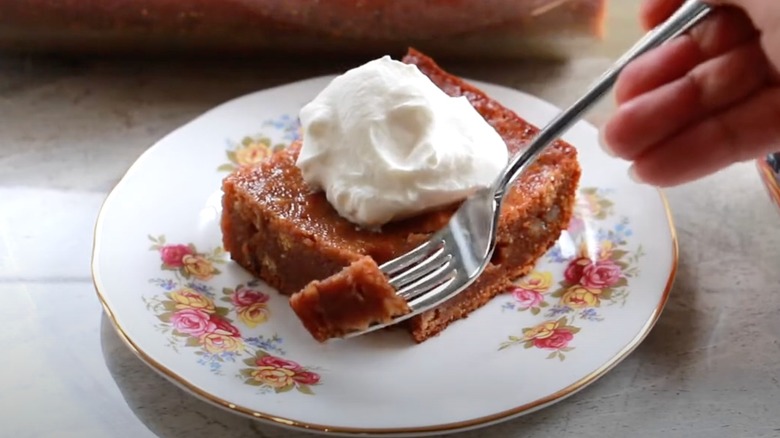 Persimmon pudding with whipped cream on decorative plate