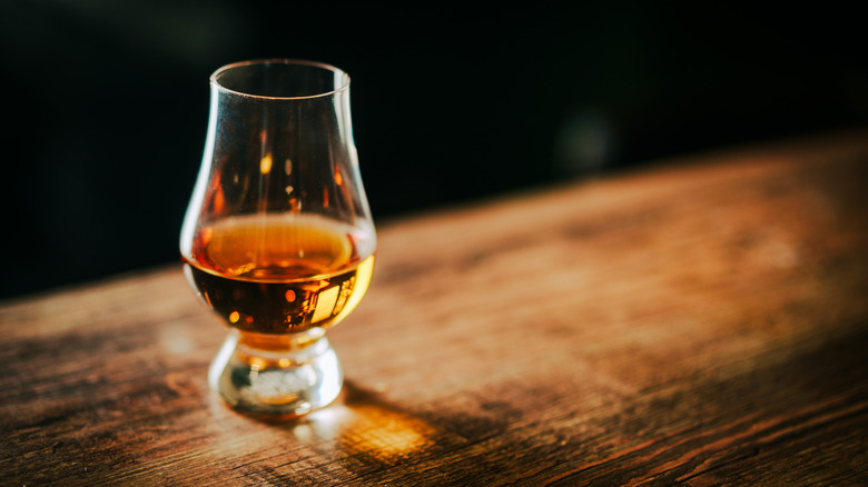 A Glencairn glass with a tasting amount of whiskey in it