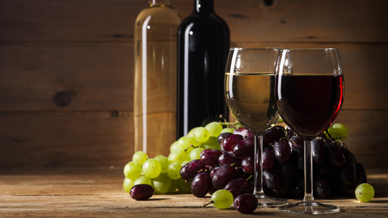 glasses of wine with grapes in background