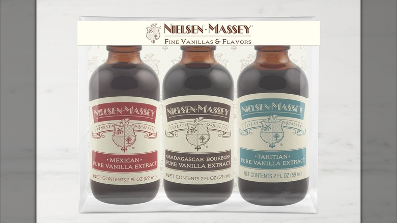 Three large bottles of vanilla extracts labeled Mexican, Madagascar Bourbon, and Tahitian