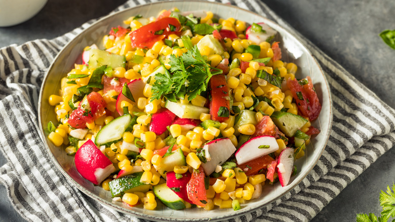 Multi-colored sweet corn salad in white bowl