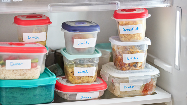 Collection of plastic food storage containers in fridge