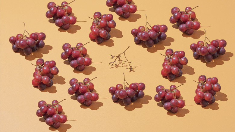 a group of red grapes laid out on an orange background