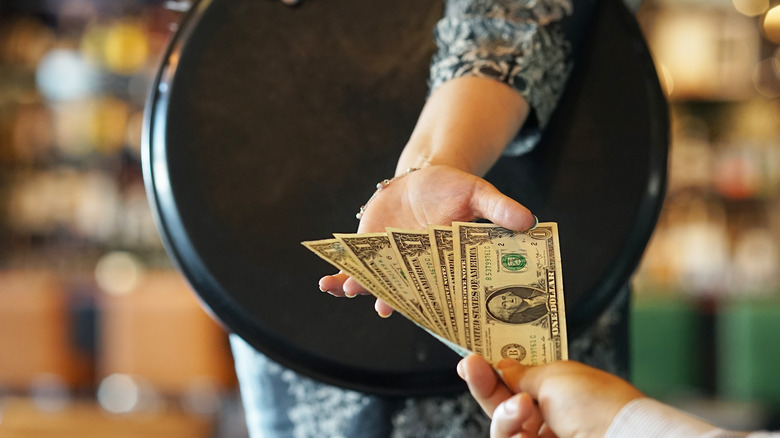 diner giving a server a cash tip