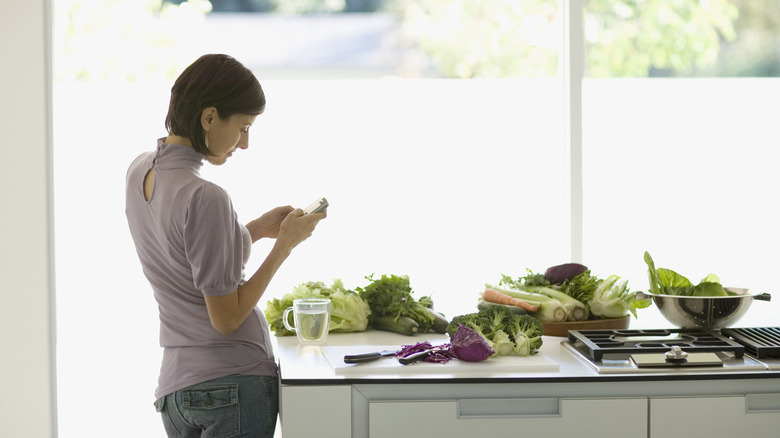 woman looking at phone in kitchen