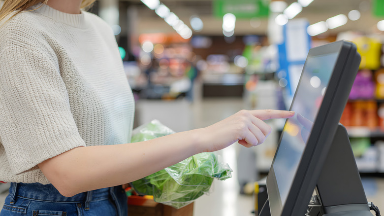 Person using self-checkout at grocery store