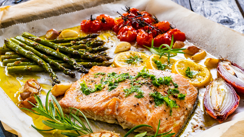 One sheet salmon, asparagus, tomato dinner on pan