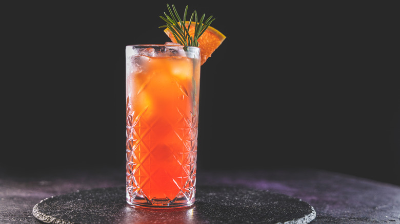 Red-orange cocktail in highball glass