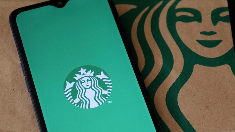 Starbucks app on phone with food bag