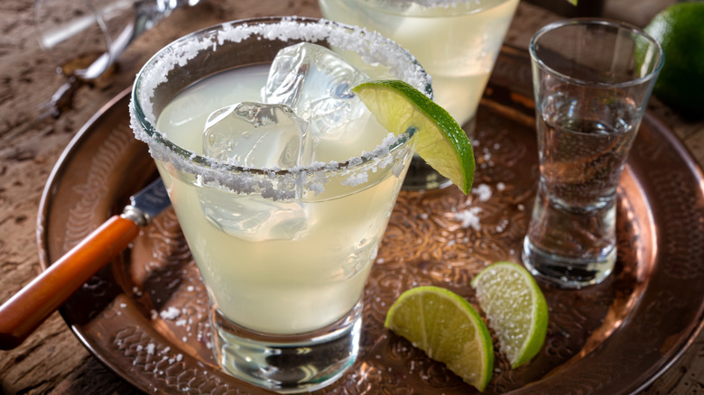Margarita on a tray with wedges of lime