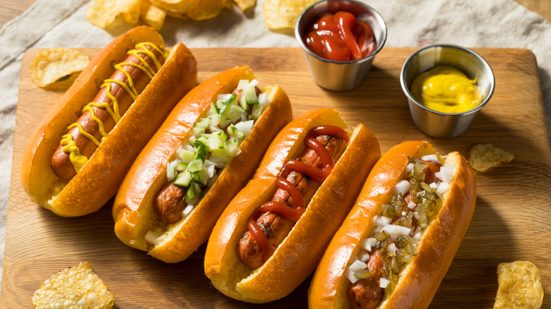 4 turkey hot dogs in buns with assorted toppings