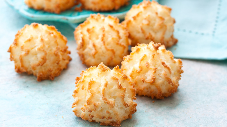 Five coconut macaroons, with well-toasted peaks of whipped egg whites, on a blue table