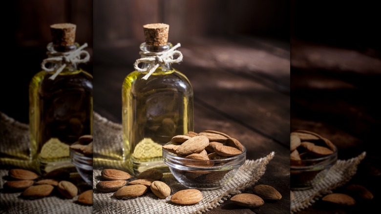 Almond oil in bottle and dried almonds