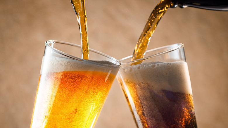 Golden ale and brown ale being poured into pint glasses