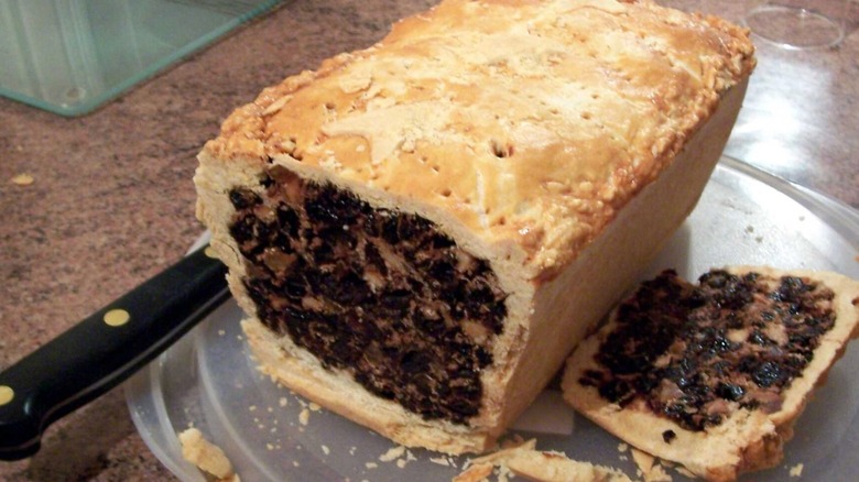 Loaf-shaped black bun, sliced open to show the filling