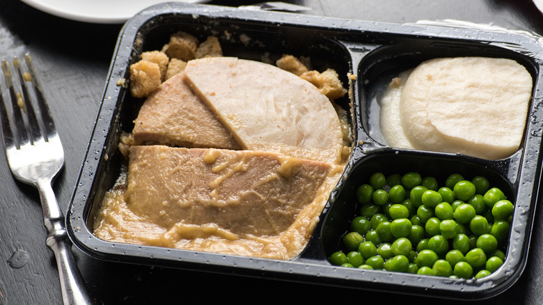 A frozen turkey dinner, featuring turkey slices, mashed potatoes, and peas