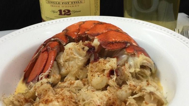 A cooked lobster tail on a bed of vegetables