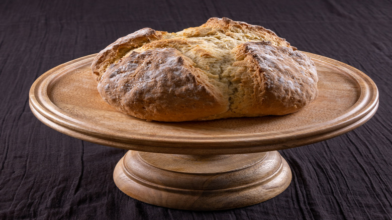 A loaf of soda bread on a wooden board