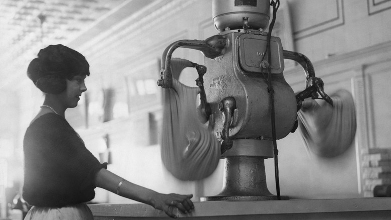 Photo of a working girl surveying a taffy-pulling machine