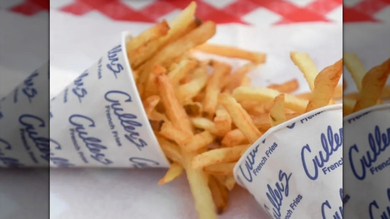 Two cones of Cullers French fries set out on a paper-covered table