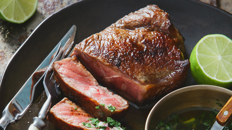 Close up of sliced steaks with the oil from confit next to it