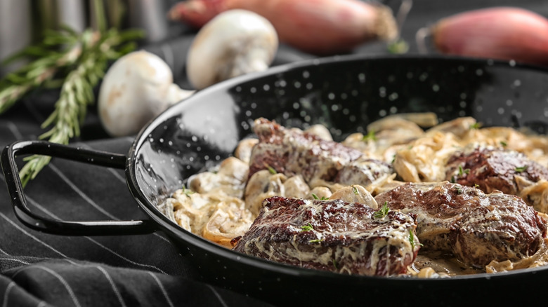 Steak Diane in a black dish on a table