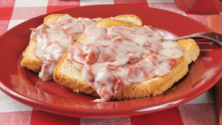 A red plate of creamed chipped beef on toast
