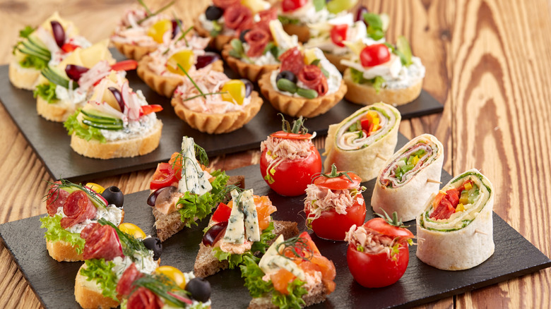 Two trays of various finger foods side by side