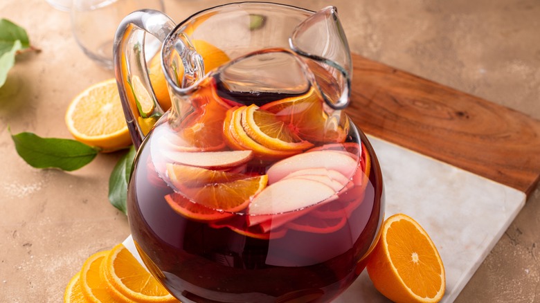Pitcher of sangria on countertop with orange slices