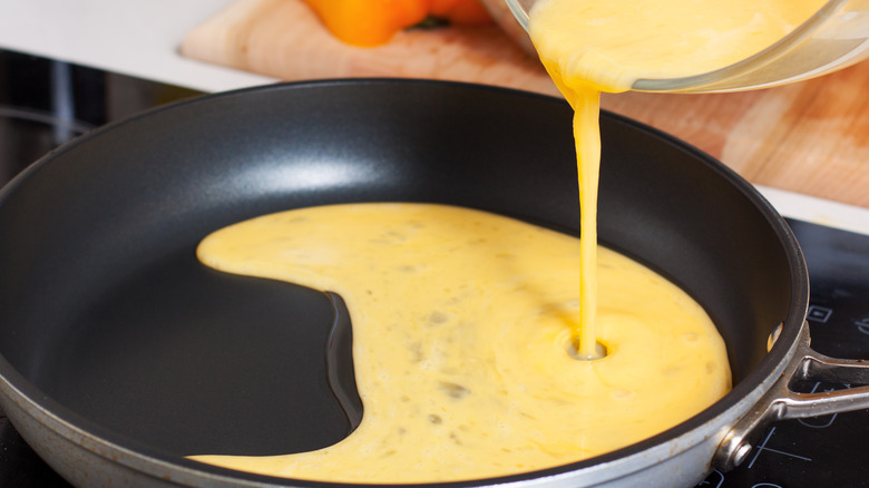 pouring eggs in a pan