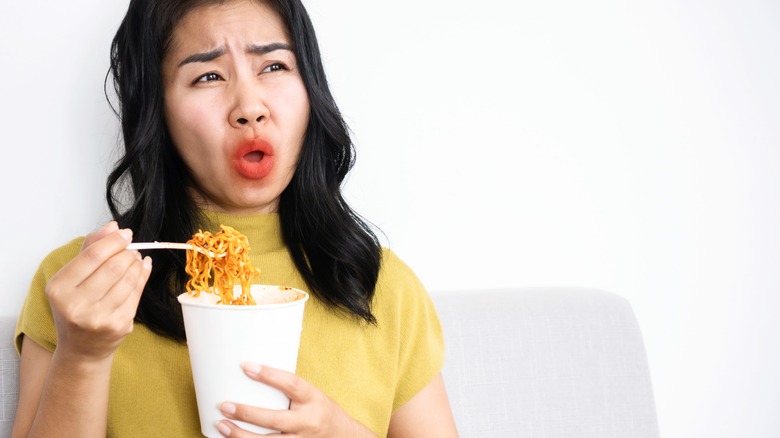 Woman eating spicy noodles